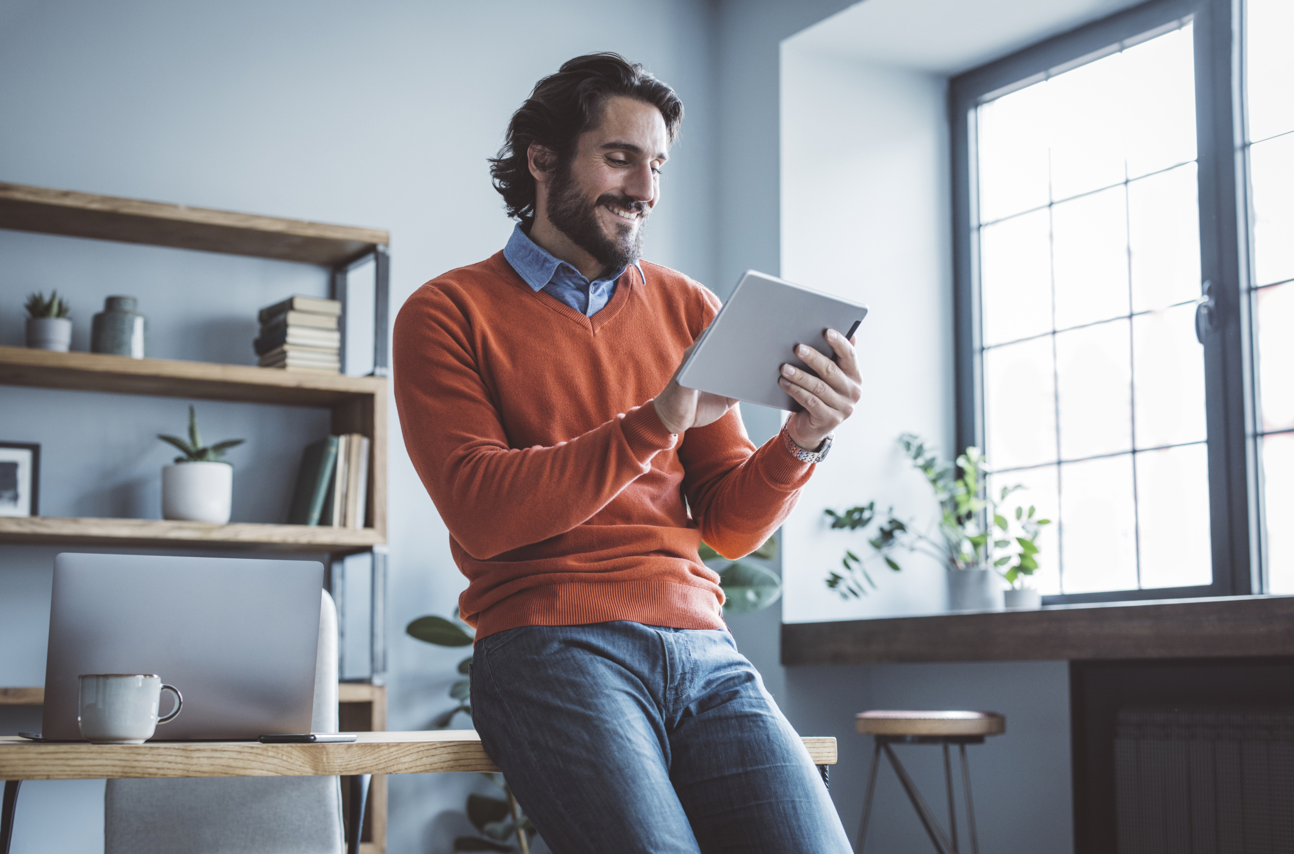 Businessman working from home officeBusinessman leaning on the table and working on digital tablet.
