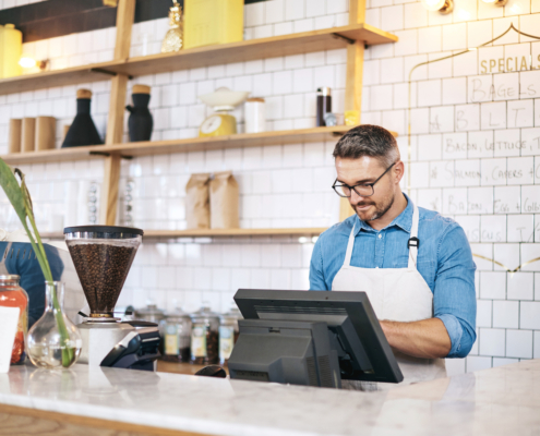 Reaping the revenue of a well run coffee shopShot of a mature man working behind the counter of a coffee shop